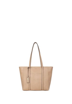 Beżowa torba na ramię ze skóry z dwoma długimi rączkami i małą zawieszką, stojąca pionowo na białym tle.