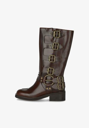 Bota de cuero marrón hasta la mitad de la pantorrilla con cuatro hebillas de latón ajustables en el tubo y dos hebillas alrededor del tobillo, suela de tacón cuadrado.