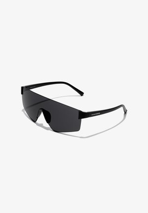Czarne okulary przeciwsłoneczne w stylu pilotaże z szeroką soczewką, elegancką czarną oprawką i wyraźnym mostkiem nosowym. Z minimalnym logo po boku.