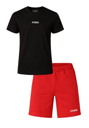 Maglietta nera a maniche corte con scritta "PYREX" e pantaloncini elasticizzati rossi con scritta "PYREX" sulla gamba sinistra.