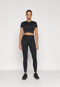 Black cropped athletic top and high-waisted leggings, both in a sleek, fitted design. Textured fabric with no visible patterns or accents.
