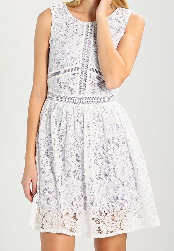 Robe en dentelle blanche avec un corsage ajusté, un col rond et une jupe évasée. Présente des motifs floraux complexes et un design texturé.