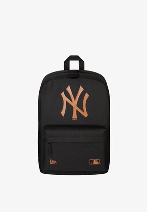 Black backpack with large front pocket featuring a stylized orange logo and two small orange brand logos at the bottom.