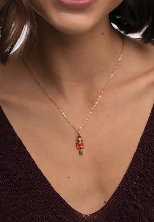 Gouden ketting met houtsnijderhanger, ontworpen met rode, groene en gouden accenten. De ketting heeft een langgerekte schakellook.