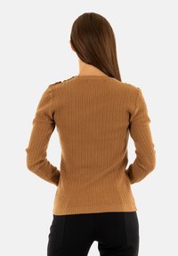 Maglione marrone lavorato a maglia con texture a costine, maniche lunghe e scollatura rotonda, decorato con bottoni sulle spalle.