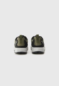 Black and olive green sneakers with a textured upper, contrast gray midsole, and a pull tab at the heel for easy wear.