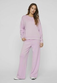 Conjunto de sudadera de color púrpura claro y pantalones de pierna ancha, fabricado en un tejido suave, con escote redondo y corte relajado, con un detalle mínimo.