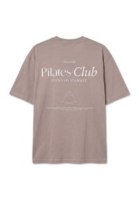 Μπεζ T-shirt με το κείμενο «PEGADOR Pilates Club FOCUS ON YOURSELF» και διάγραμμα Venn του νου, του σώματος και της ψυχής στην πλάτη.