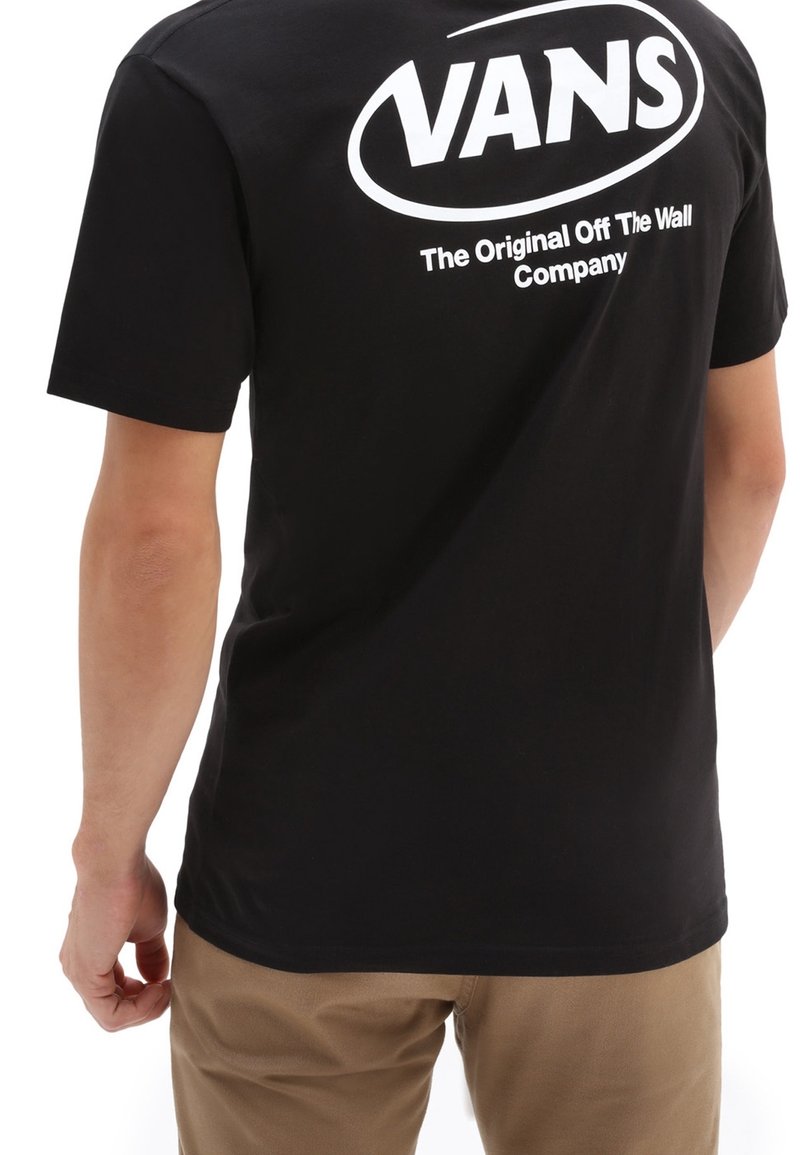 T-shirt en coton noir avec un grand logo blanc "VANS" au dos et un texte en dessous. Manches courtes, coupe standard, texture lisse.