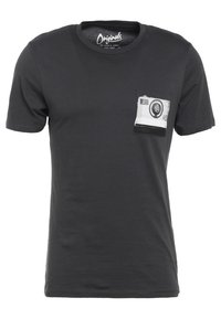 Camiseta de algodón negra con cuello redondo, que presenta un bolsillo en la parte frontal adornado con un diseño de cámara vintage impreso en blanco y gris.