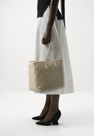 Borsa a spalla color sabbia con una trama intrecciata e un motivo di piccoli accenti blu e oro. Presenta lunghe maniglie bianche e un interno arancione in contrasto.
