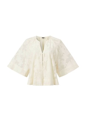 Chemisier en dentelle couleur crème avec manches larges arrivant au coude, motif floral, encolure ronde et fermeture à boutons sur le devant.