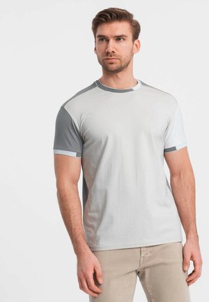 Camiseta de manga corta en gris y gris claro con cuello redondo, que presenta paneles de hombro en contraste y una textura de tela suave.