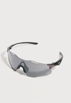 Occhiali da sole sportivi avvolgenti con lente singola curva tinta di grigio e aste nere su sfondo bianco.