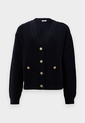 Mornarska rebrasta kardigan s V-izrezom, sadrži šest zlatnih dugmadi i dva prednja džepa. Mekana tekstura i uski rukavi zaokružuju dizajn.