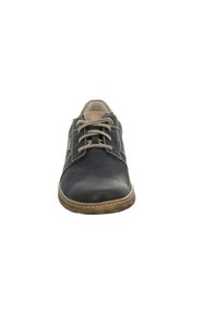 Scarpa in pelle nera con finitura testurizzata, cuciture a contrasto più chiare, punta tonda e dettagli beige. Presenta un classico design con lacci.