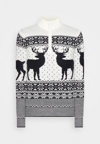 Stickad tröja med hög krage och dragkedja, mönstrad med svarta renar och snöflingor mot en vit bakgrund. Ribbad mudd och nederkant.