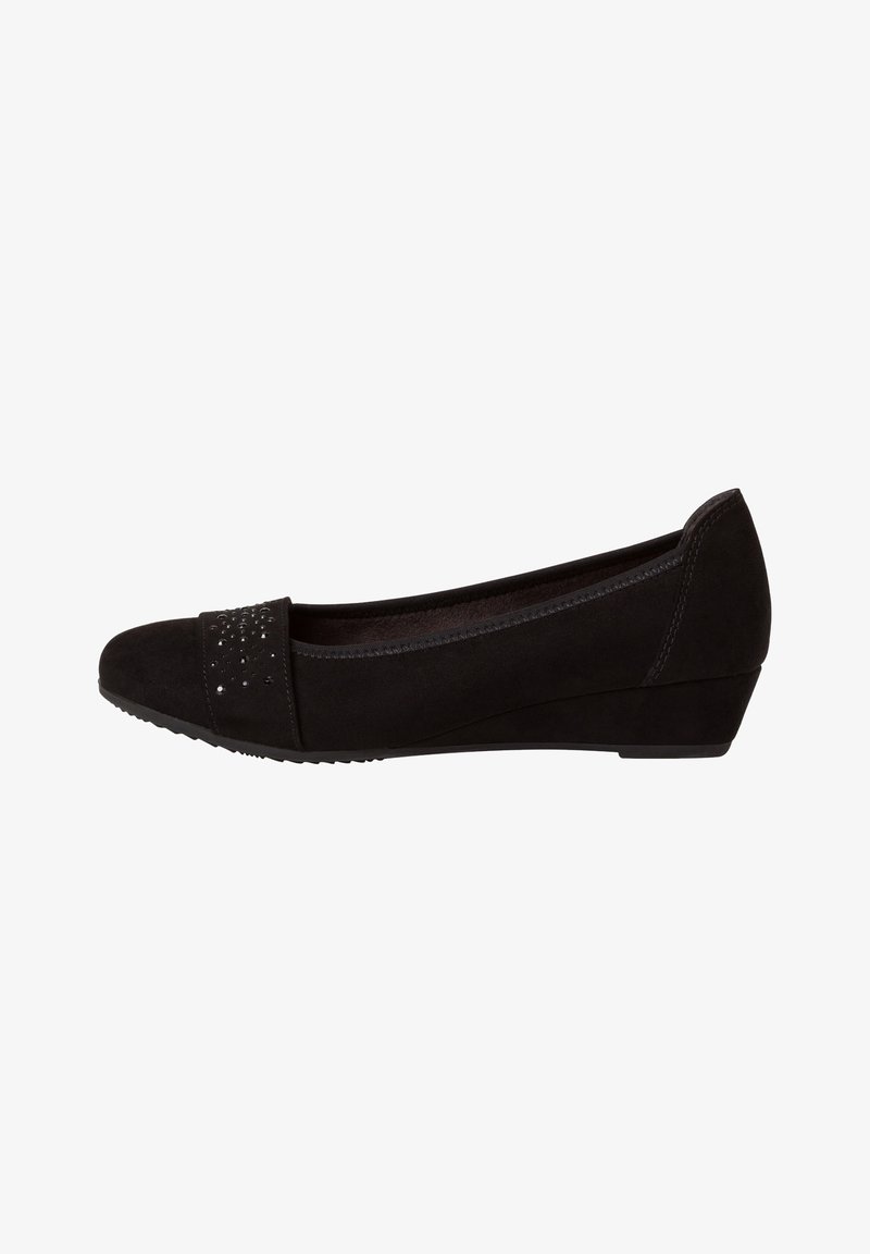 Chaussure plate en daim noir à petit talon compensé avec bride cloutée décorative sur l’avant, bout arrondi et détails cousus sur les côtés.