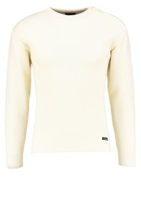 Kremowy, prążkowany sweter z długimi rękawami, okrągłym dekoltem i ozdobnym guzikiem na ramieniu, z małą metką marki u dołu.