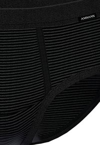 Schwarz gestreifte Unterwäsche mit einem strukturierten Bund. Das Material ist glatt, mit horizontalen Streifen und einem Logoetikett am Bund.