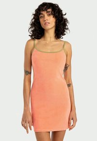 Pfirsichfarbene ärmellose Kleid mit enganliegendem Design, gefertigt aus weichem Stoff. Verfügt über dünne Träger und kontrastierende olivgrüne Akzente.