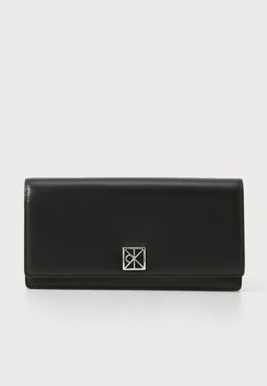 Black leather wallet with a smooth texture, rectangular shape, and a silver geometric logo on the front flap.
