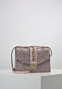 Borsa in velluto mauve con texture, dotata di una catenina dorata e di una tracolla in pelle rosa. Presenta una chiusura magnetica e un design a barriera angolare.