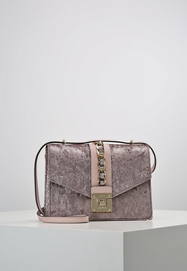 Borsa in velluto mauve con texture, dotata di una catenina dorata e di una tracolla in pelle rosa. Presenta una chiusura magnetica e un design a barriera angolare.