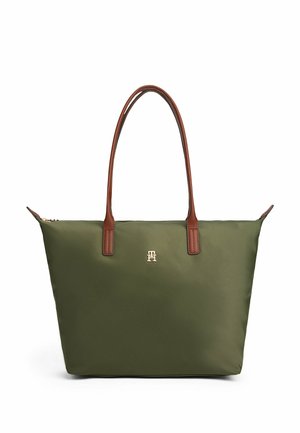 Groene tote bag met bruine leren handvatten en een klein gouden embleem aan de voorkant, weergegeven op een witte achtergrond.