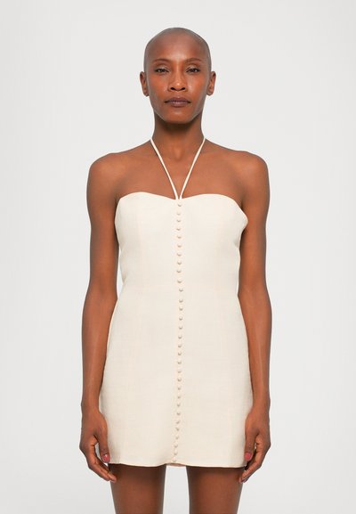 Robe crème sans bretelles avec un design ajusté, des détails de boutons sur le devant et un ourlet droit. Fabriquée en tissu léger et texturé.