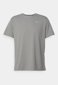 Camiseta gris de Nike con escote redondo, mangas cortas y un pequeño logo en el pecho. Fabricada con una tela suave y ligera.