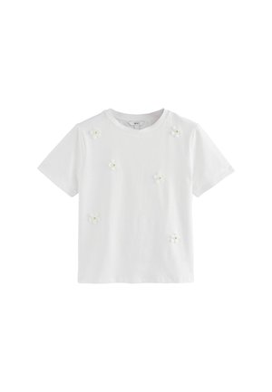 T-shirt blanc à manches courtes en coton doux, orné d'appliqués en forme de fleurs en tissu en grappes pour décorer le devant.