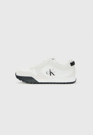 Calvin Klein white sneaker with black sole, suede and mesh panels, CK logo on side, and Calvin Klein branding on heel and sole.