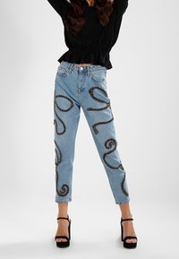 Jeans in denim azzurro chiaro con ricami neri a forma di serpente lungo i lati; design a gamba dritta, vita alta e stile a cinque tasche.