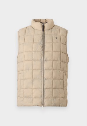 Beige quiltet ermeløs vest med høy krage og glidelås foran, med lite brodert logo på venstre bryst.