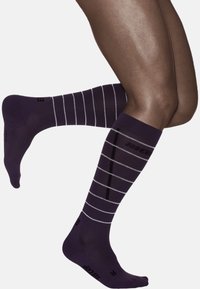 Purple knee-high socks with white horizontal stripes, featuring textured material and reinforced toe areas, designed for comfort and support.