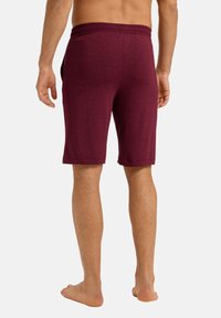 Shorts bordeaux a ginocchio realizzati in tessuto morbido, dotati di vita elasticizzata e tasche laterali, progettati per comfort e libertà di movimento.