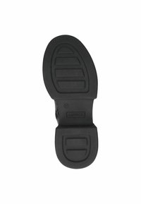 Suela de zapato de goma negra con patrón texturizado, que presenta surcos horizontales y un acento circular cerca del talón. Marcada con "Caprice" y tamaño 37.