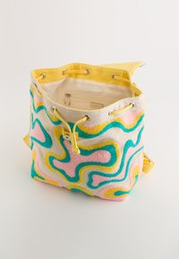 Sac en toile avec accents jaunes, présentant un motif texturé rose, bleu et jaune. Fermeture à cordon et poche intérieure.