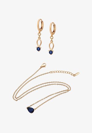 Ohrstecker in Goldoptik mit blauem Edelstein, tropfenförmig und hängend gestaltet. Passende Halskette in Goldoptik mit ähnlichem Edelsteinakzent.