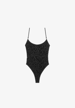 Musta yhdistevä uimapuku, jossa on teksturoitu seeprakuosi, ohuet hihnat ja korkea lahjeprofiili. Mukana huomaamattomat varusteet.