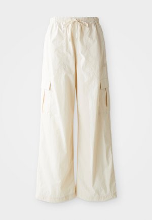 Weite Cargo-Hosen aus hellbeigem Stoff mit elastischem Bund, Kordelzug und Seitentaschen. Glatte Textur mit minimalen Details.