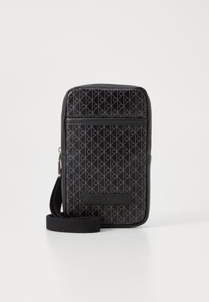 Sac messager noir avec un motif géométrique, fabriqué en matériau texturé. Dispose d'une bandoulière réglable et d'une poche zippée à l'avant avec une ornementation de logo.