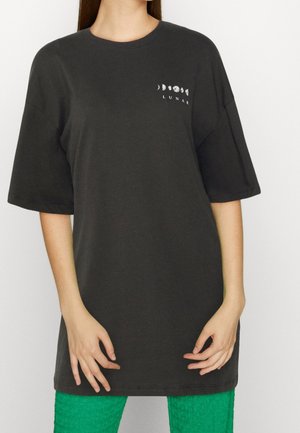 Zwart oversized T-shirt van katoen, met korte mouwen, een ronde halslijn, en witte bedrukte maanfases met de tekst "LUNAR".