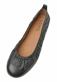 Schwarze Leder-Ballerina mit einem gerafften elastischen Obermaterial und einer runden Zehenpartie. Das Innere zeichnet sich durch ein glattes, braunes Futter aus.