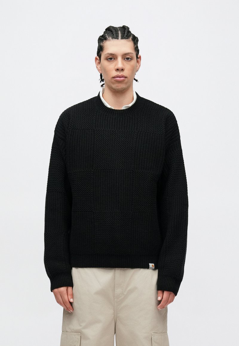 Sort strikket sweater med et tekstureret, ternet mønster, rund halsudskæring og ribbet kant ved ærmerne. Lille logo-tag ved kanten.