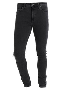 Jeans de denim negro con un ajuste slim, diseño de cinco bolsillos, trabillas para cinturón y detalles sutiles de costura a lo largo de las costuras.