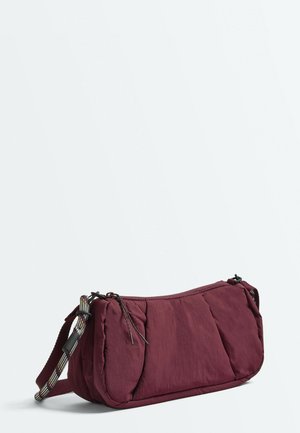 Petit sac bandoulière rectangulaire bordeaux avec des détails en tissu froncé et une bandoulière réglable avec un motif noir et blanc.