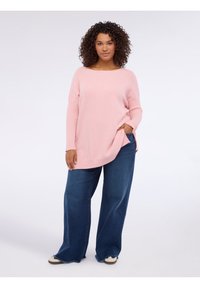 Maglione rosa chiaro lavorato a maglia con dettagli a coste, maniche lunghe e tasche laterali, abbinato a jeans di jeans blu a gamba larga e scarpe casual.