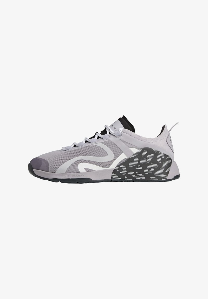 Světlá šedá sportovní bota s vrchní částí z prodyšné síťoviny, texturovaným černo-šedým vzorovaným podpatkem a bílými detaily. Má tkaničky a polstrovaný límec.